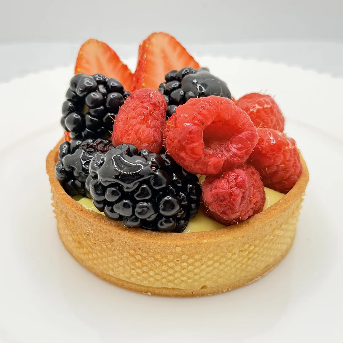 Seasonal berry tart topped with blackberries, raspberries, and strawberries
